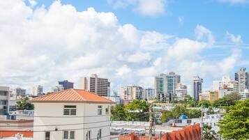 A cityscape with modern buildings, a clear sky, and a street with vehicles.