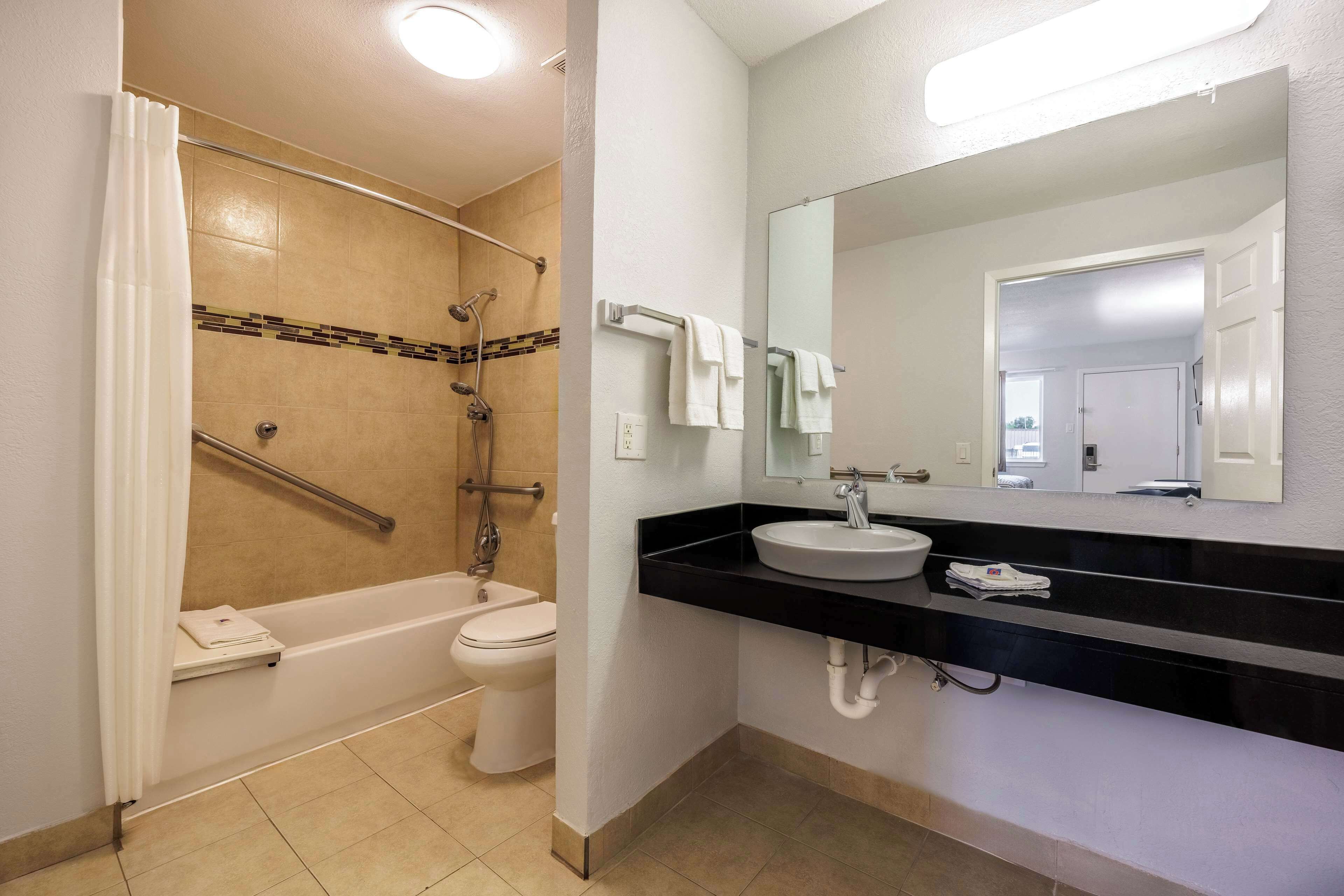 A bathroom with a bathtub, toilet, and sink.