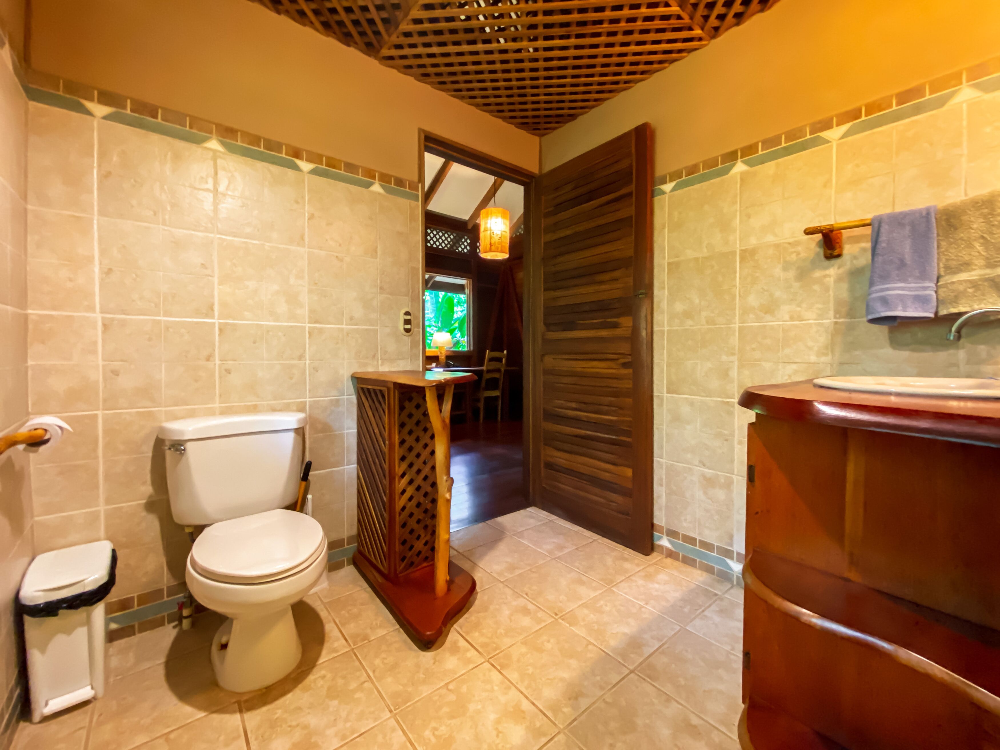 A bathroom with a toilet, sink, and shower area.
