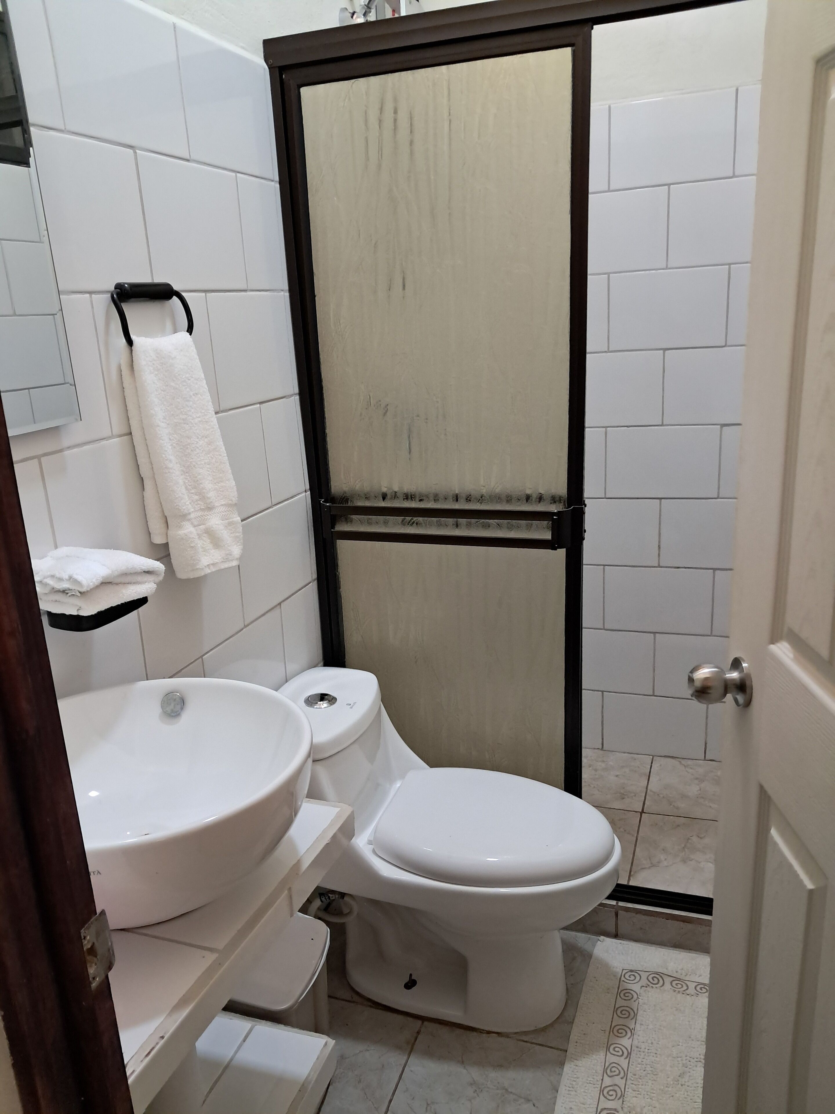 A bathroom with a toilet, sink, and towel rack.