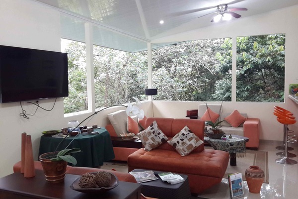 Villa Oso Perezoso Aire Acondicionado | Living area | 32-inch Smart TV with cable channels, books, printers