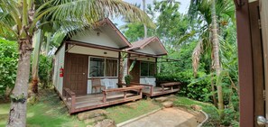 Simple, residence surrounded by lush greenery and tropical plants.