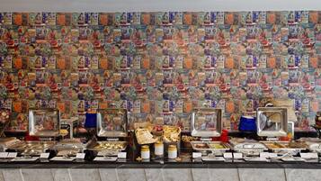 Un buffet proposant une variété de plats et un mur décoré de vieux magazines.