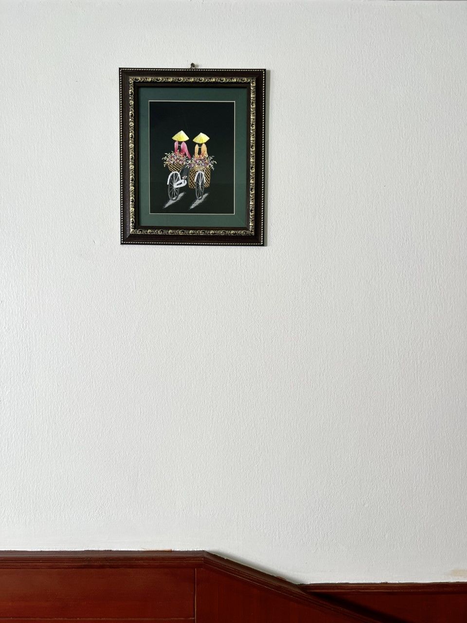 A framed artwork on a plain wall.