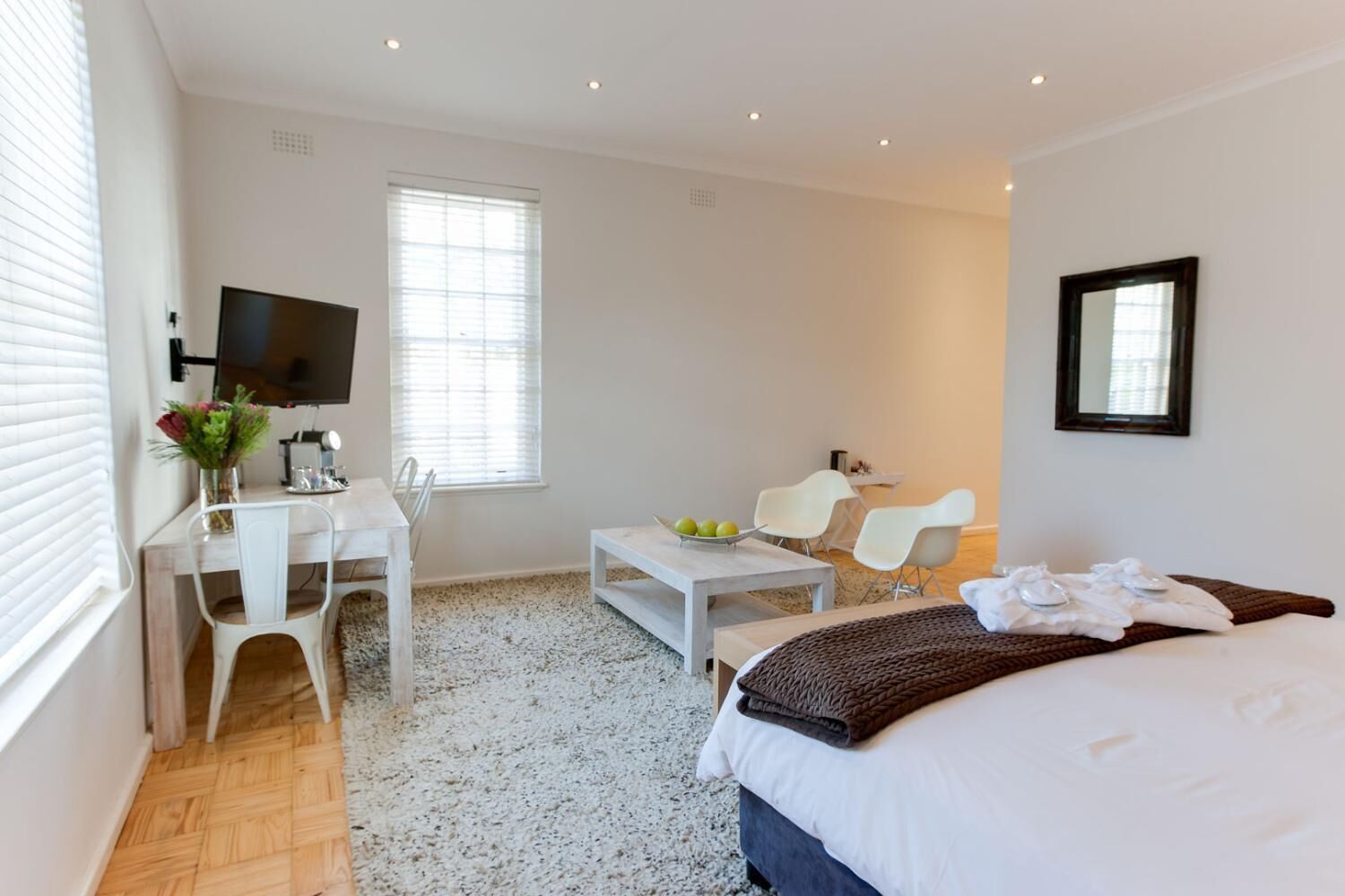 Une chambre d’hôtel comprenant un lit, un bureau avec une chaise, une table basse et un téléviseur.