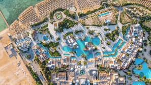 An aerial view of a resort with multiple swimming pools, sun loungers, and palm trees. - Grand Makadi Couples and Families Only - All inclusive (Makadi Bay)
