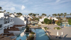 Un complexe hôtelier doté de plusieurs piscines, de palmiers et de bâtiments blancs surmontés de coupoles.