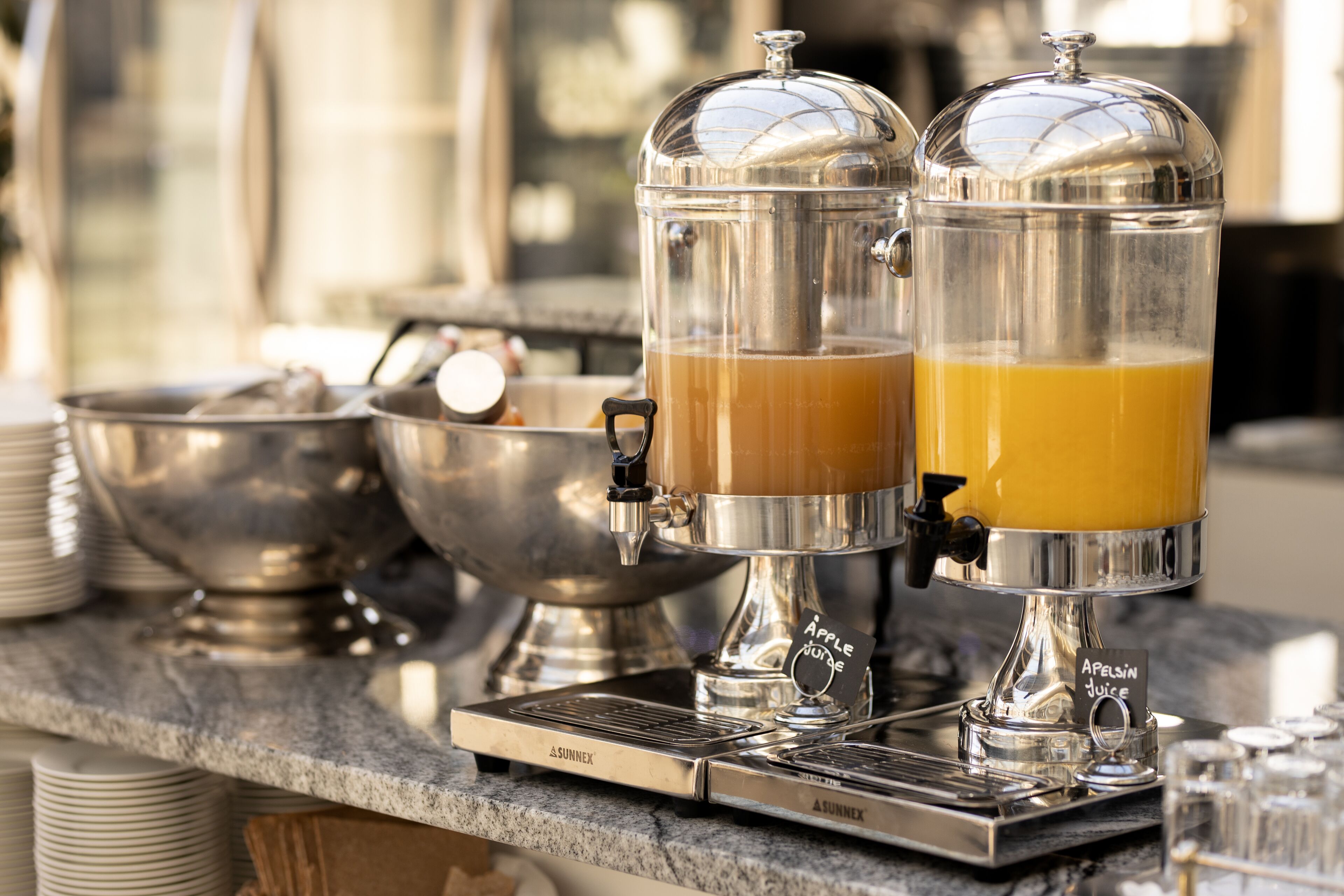 Ein Frühstücksbereich mit zwei Kaffeeautomaten und einer Obstschale.