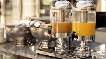 Ein Frühstücksbereich mit zwei Kaffeeautomaten und einer Obstschale.