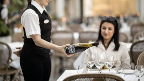 A waiter pouring wine into a glass at a restaurant table. - Gränsö Slott Hotel & Spa (Vastervik)
