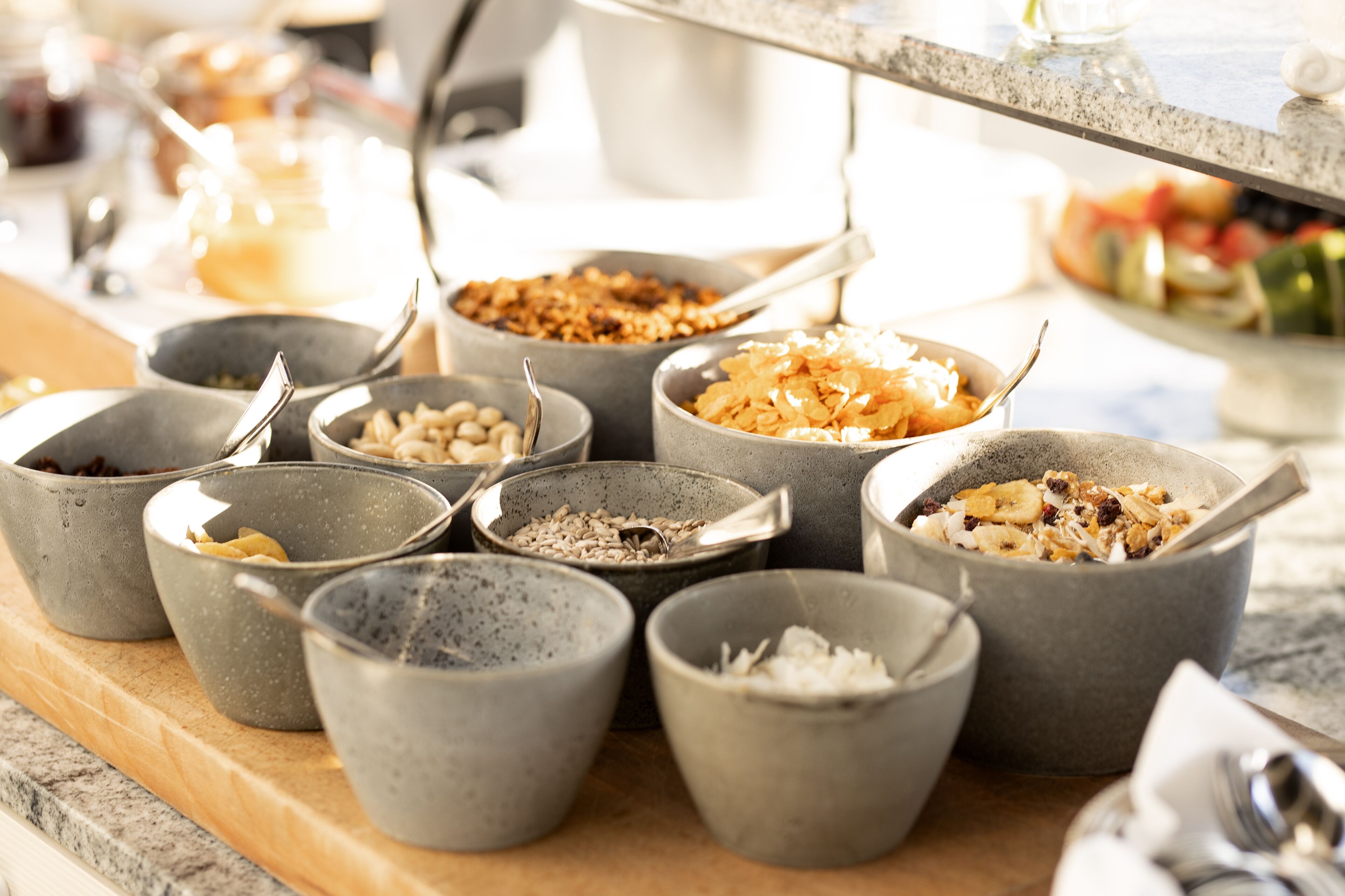 A buffet table with various food items in bowls.