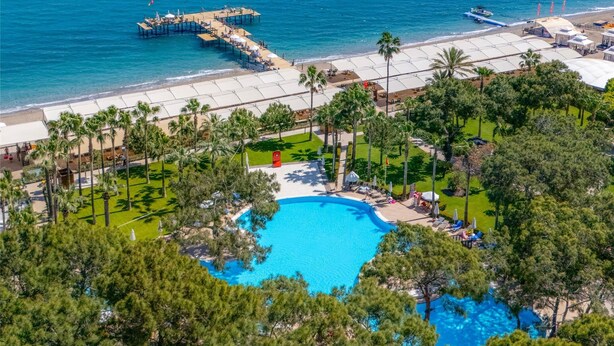 A resort with a large swimming pool surrounded by pine trees, a beach, and a pier extending into the sea. - Seven Seas Hotel Life - Ultra All Inclusive (Kemer)