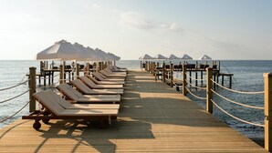 A wooden pier with lounge chairs and umbrellas, leading to a beach. - Seven Seas Hotel Life - Ultra All Inclusive (Kemer)