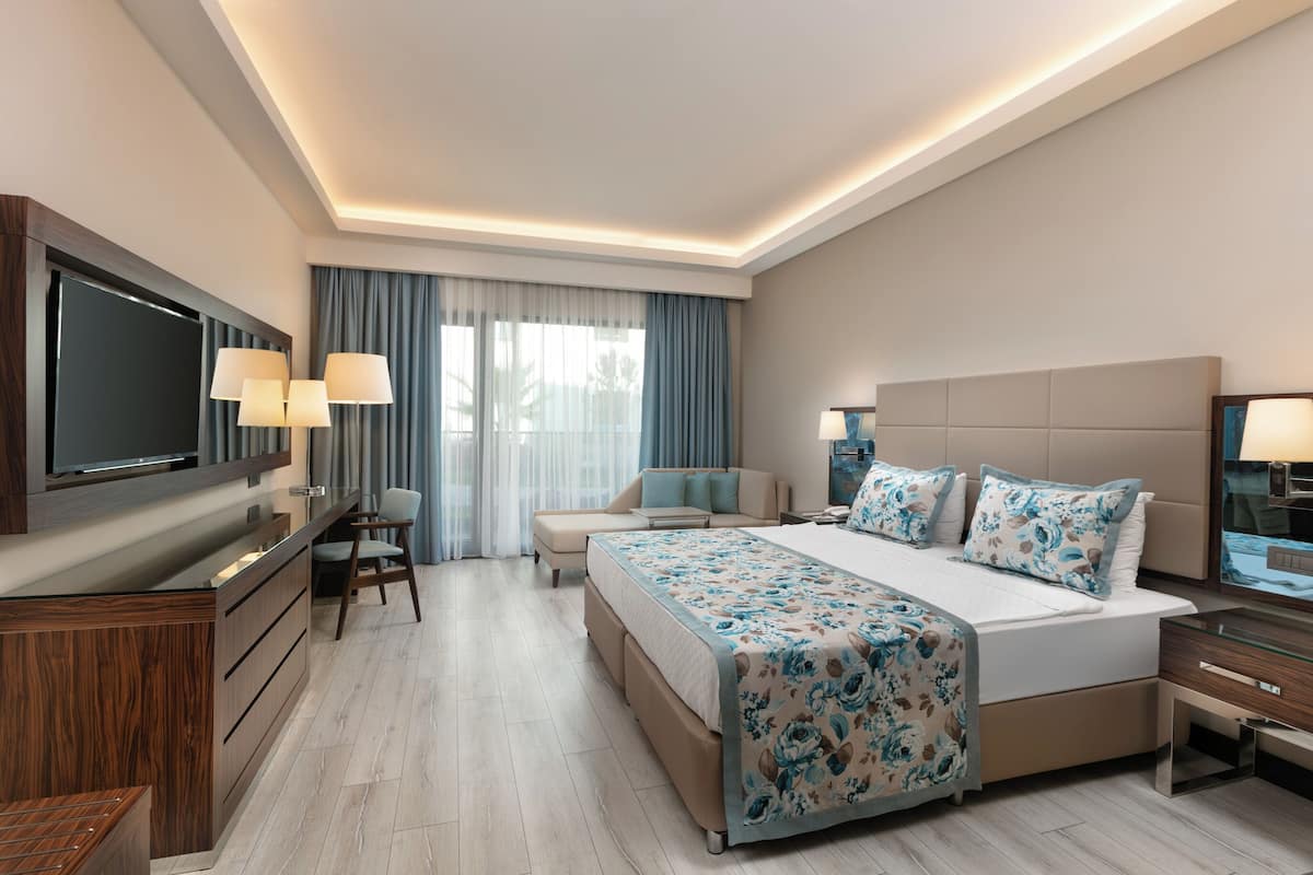 Une chambre d’hôtel moderne dotée d’un grand lit, d’un bureau, d’une télévision et d’un coin salon.