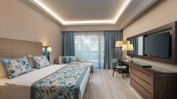 Un hotel moderno con una cama grande, un escritorio, un televisor y vistas de la ciudad a través del ventanal.