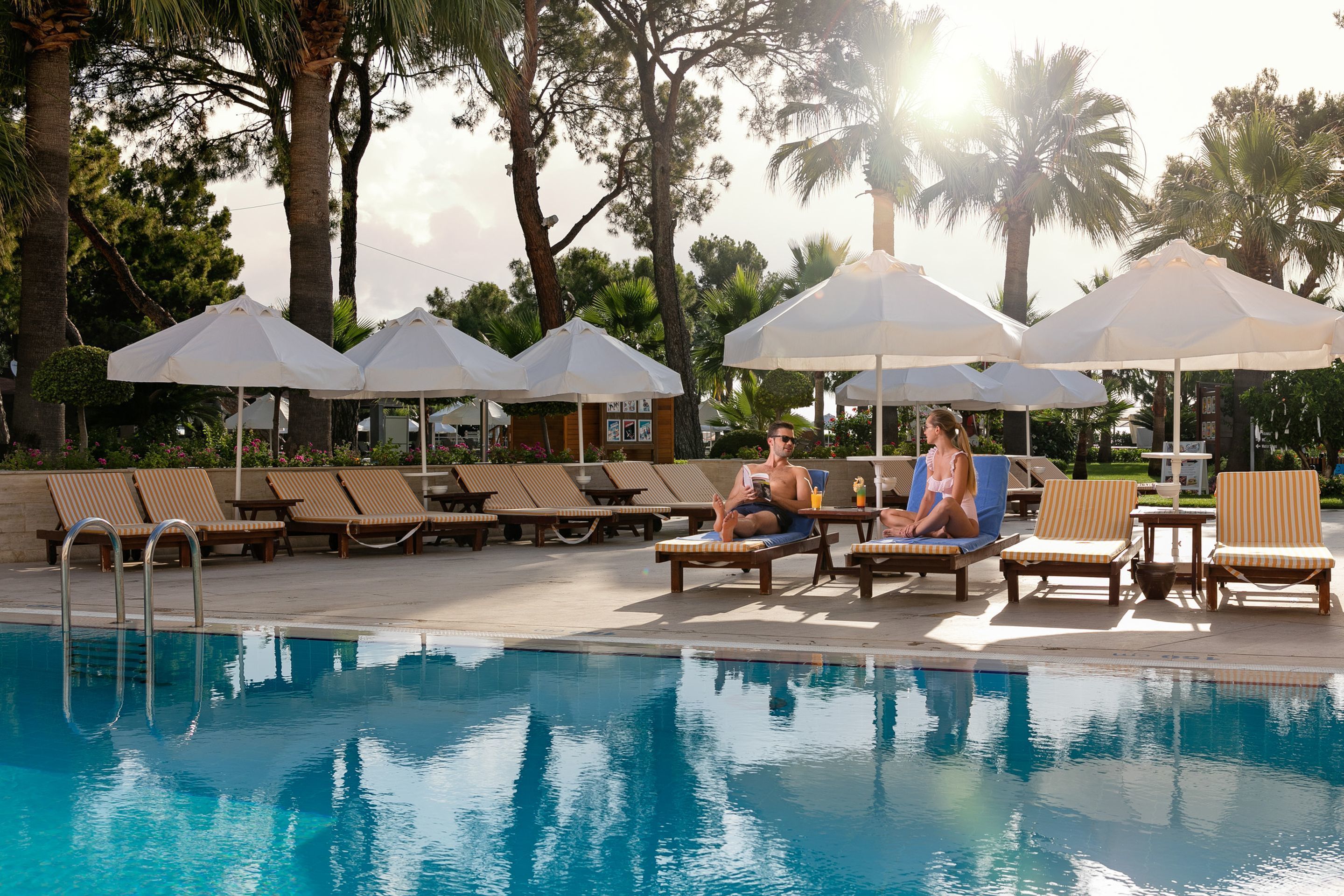 A poolside area with lounge chairs and umbrellas.