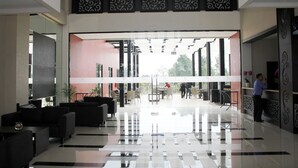 A modern lobby with a glass partition, seating area, and reception desk. - Padjadjaran Suites Resort & Convention (Bogor)