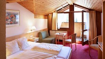 Habitación de hotel con cama, escritorio, silla y ventana.