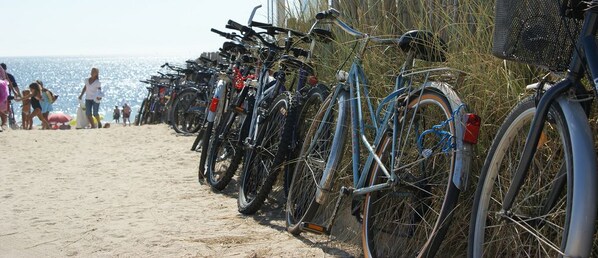 Bicicletas estacionadas numa praia arenosa.