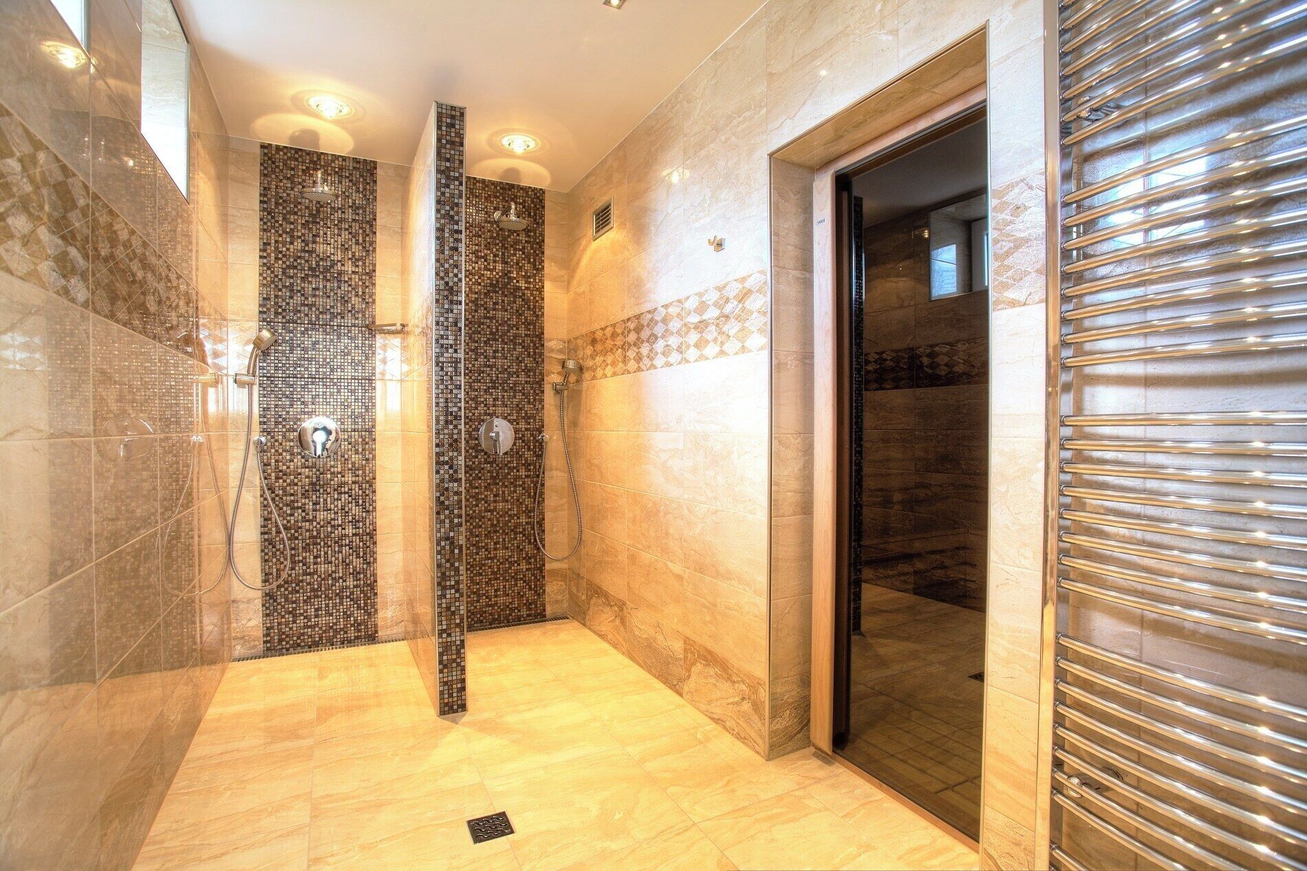 A modern bathroom with a walk-in shower, tiled walls, and a wooden floor.