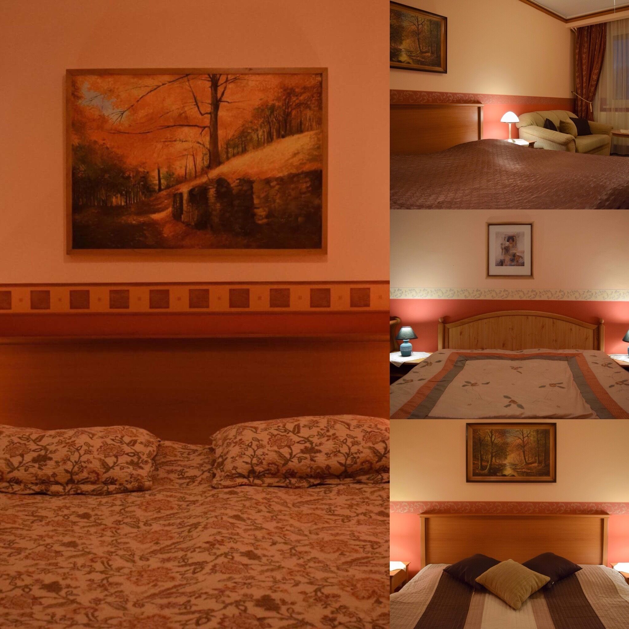 A hotel room with a bed, a painting of a forest scene, a lamp, and a nightstand.