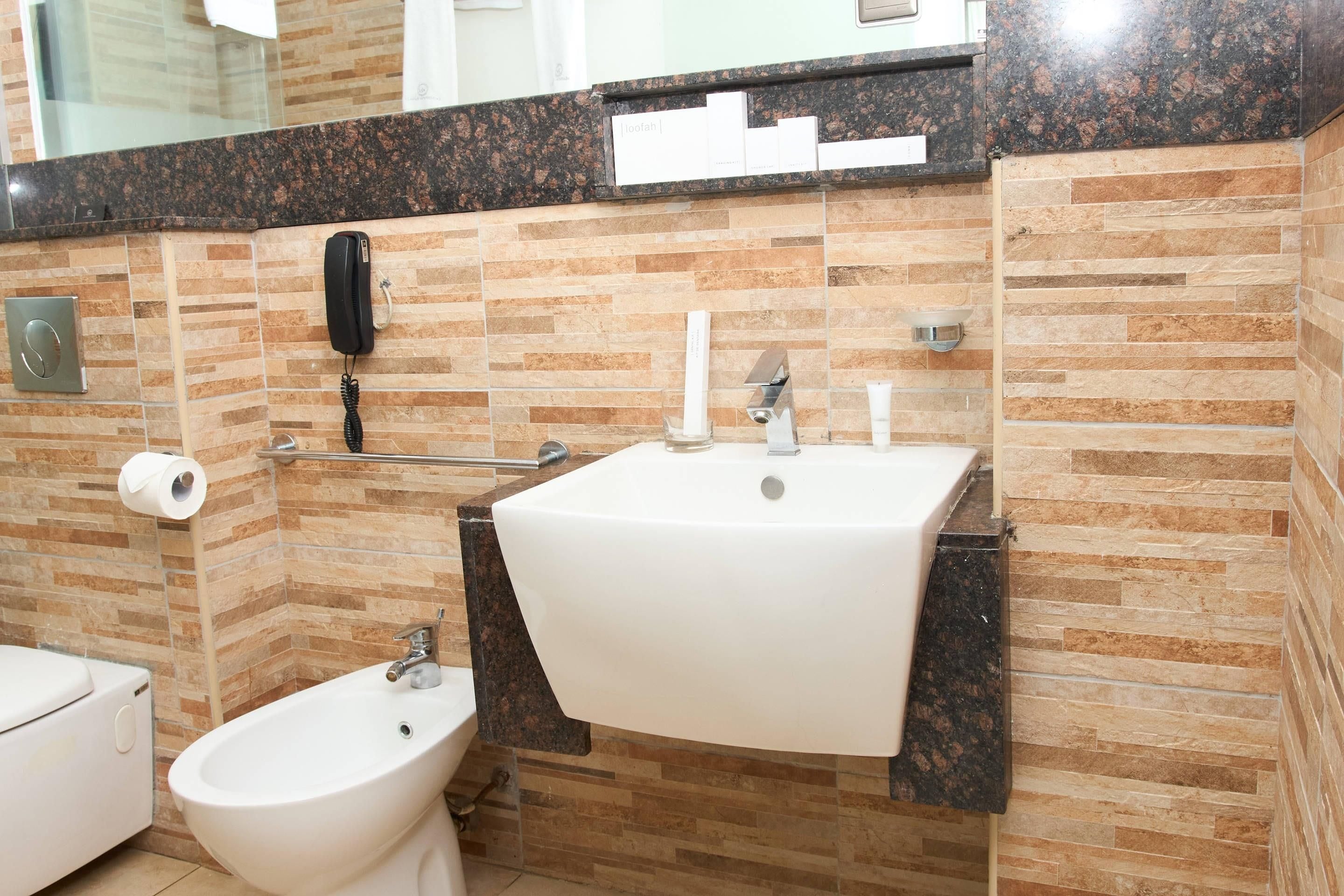Un baño con bidé, lavabo y espejo.