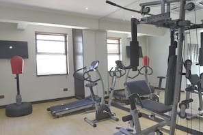 A gym with treadmills, elliptical machines, and weightlifting equipment. - La Maison Royale - Westlands (Nairobi)
