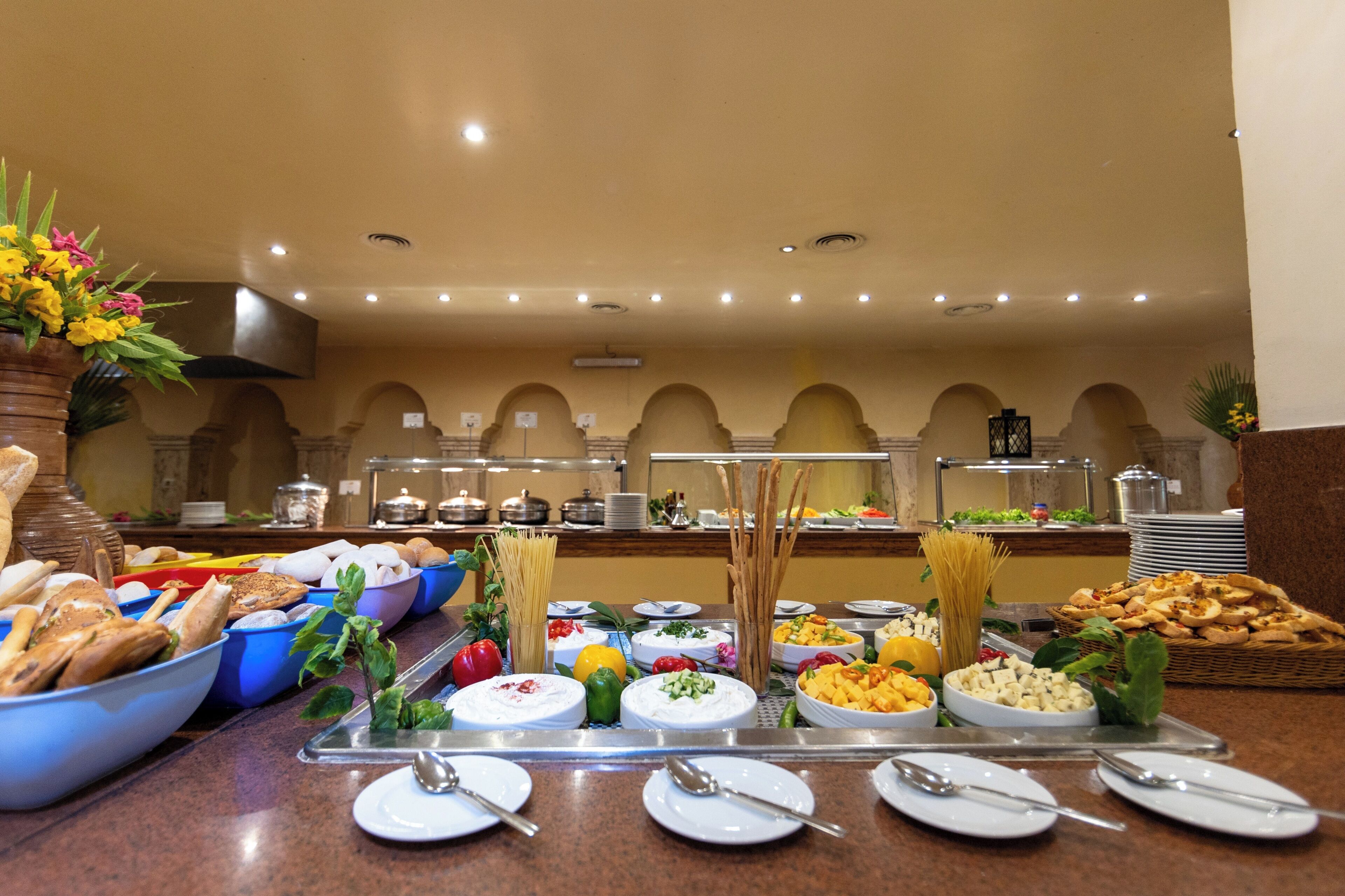A buffet with various food items and utensils.