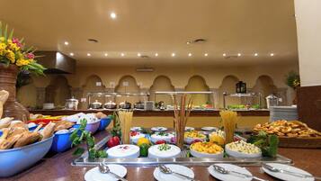 A buffet with various food items and utensils.