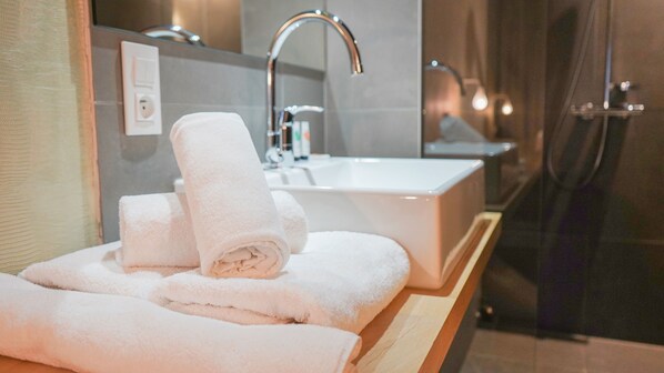 Une salle de bain avec un lavabo, un miroir et des serviettes.