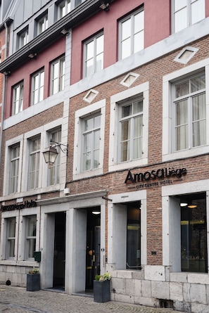A hotel with a red facade, multiple windows, and a sign reading 'Amosliege City Centre Hotel'. - Amosa Liège City Centre Hotel (Liege)