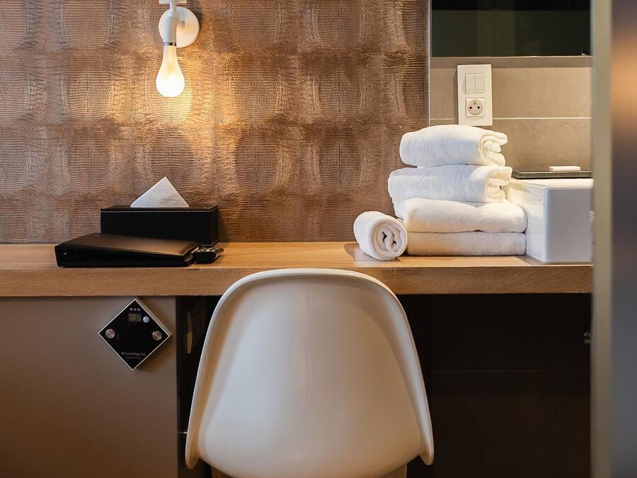 Un baño moderno con pared de madera, un espejo, un perchero y un inodoro.