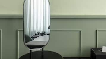 A mirror with a reflection of a room, a table with cups, and a tissue box.