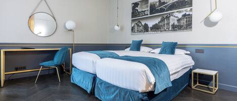 A modern bedroom with a double bed, a desk, a chair, and a small table.
