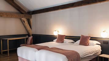 Un dormitorio con una cama grande, vigas de madera, un radiador y dos lámparas de noche.
