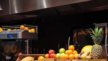 Una exhibición de frutas con cajas de madera etiquetadas 'APPLE JUICE', 'ORANGE FRESH' y 'MULTI VITAMIN'.