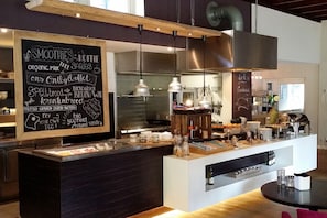 A modern café interior with a chalkboard menu listing smoothies, coffee, and organic milk. - Landgoedhotel Woodbrooke (Barchem)