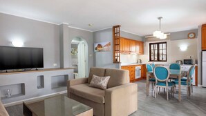 A modern living room with a flat-screen TV, a beige sofa, and a glass coffee table. - Ona Las Brisas (Yaiza)