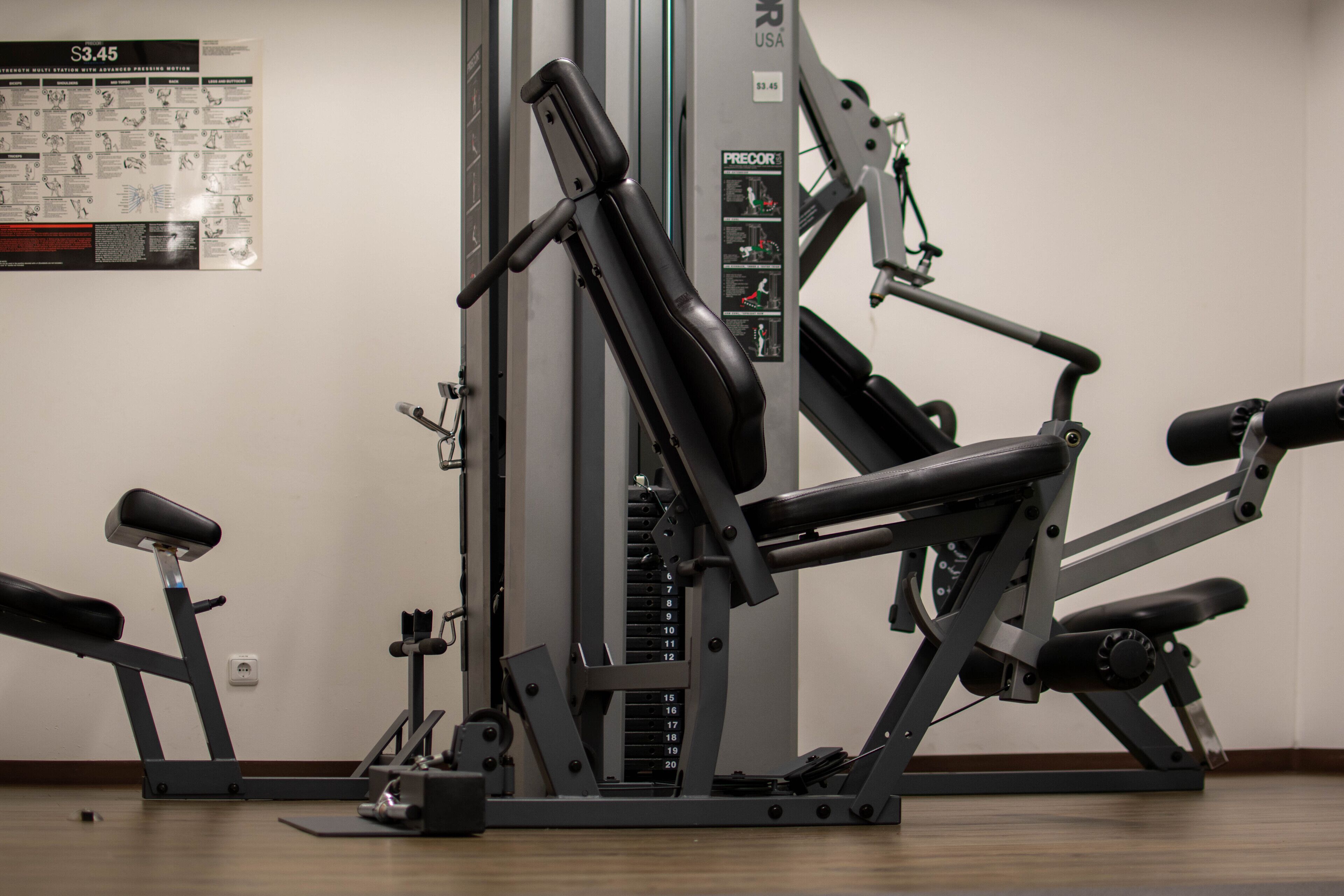 A gym with various exercise machines, including a leg press and a chest press.
