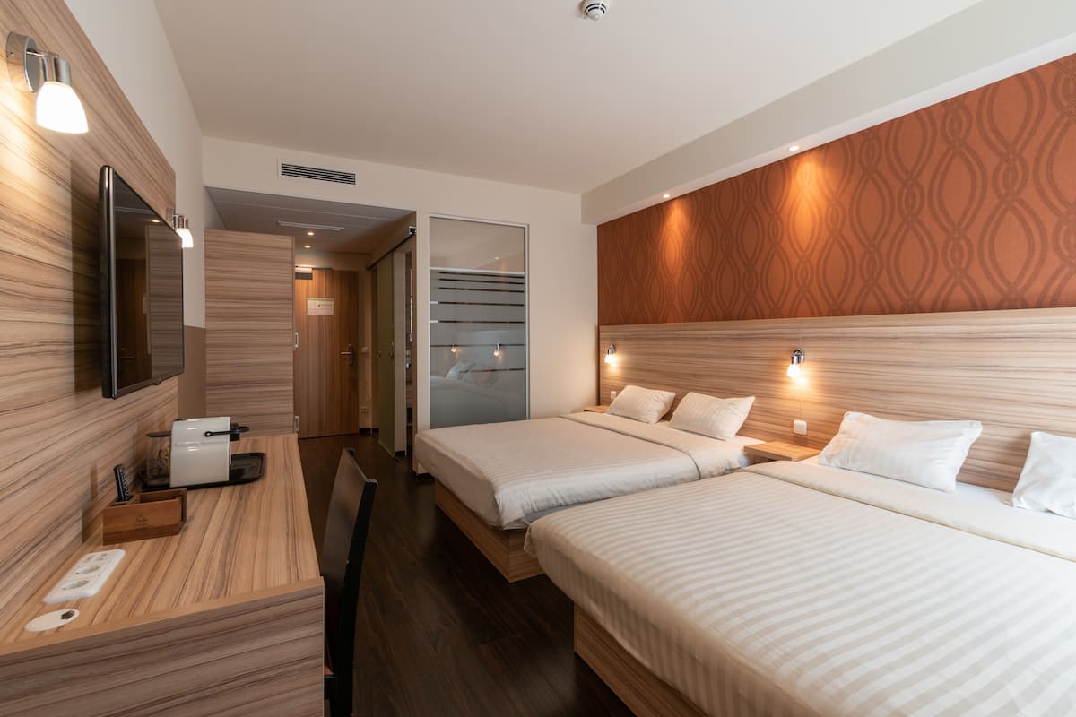 Ropa de cama hipoalergénica y caja de seguridad en la habitación