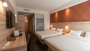 Ropa de cama hipoalergénica y caja de seguridad en la habitación
