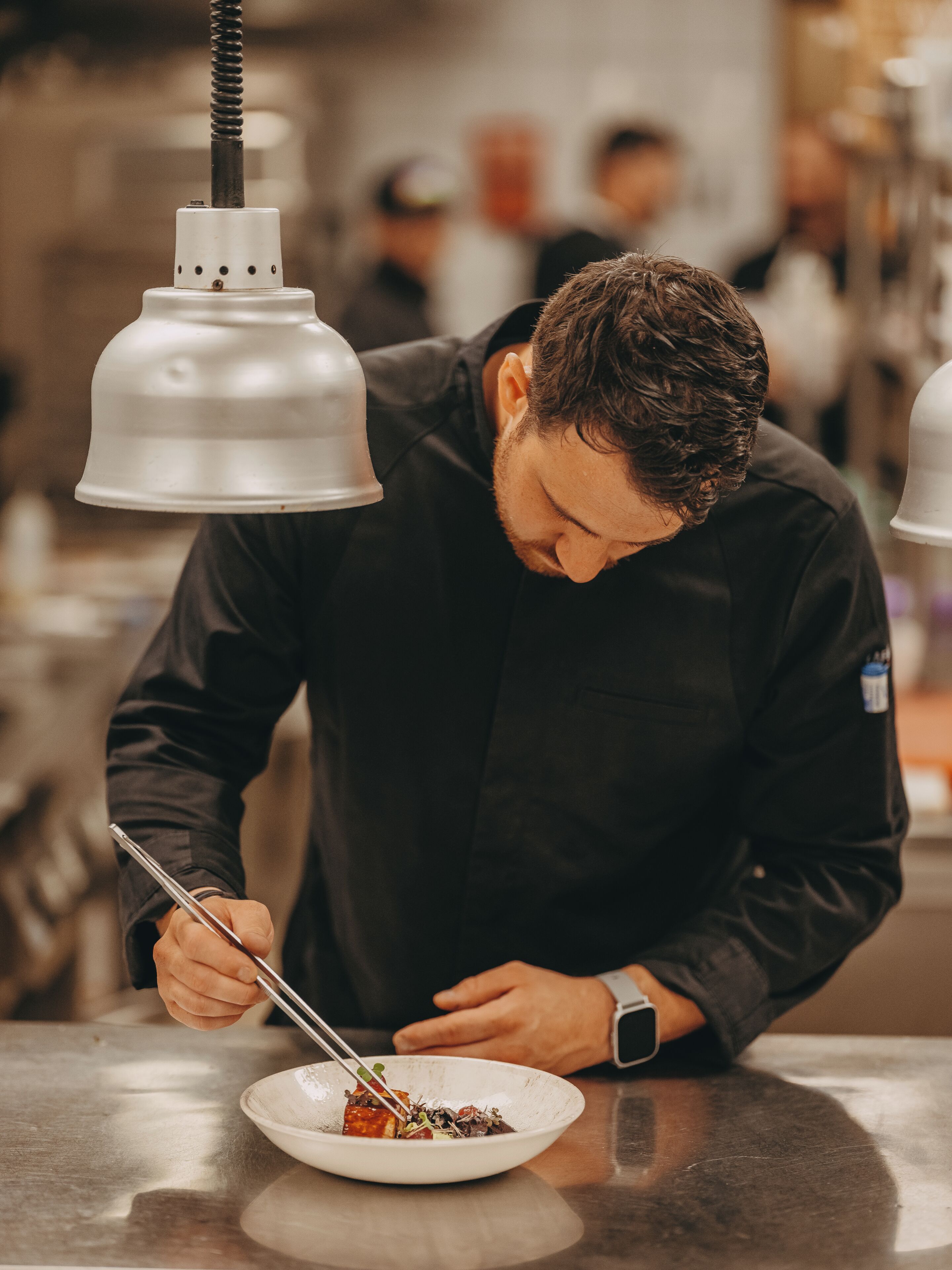 A person dining at a restaurant with a white table and a metal bowl.