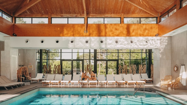 Una piscina con sillas de descanso y una estructura techada.