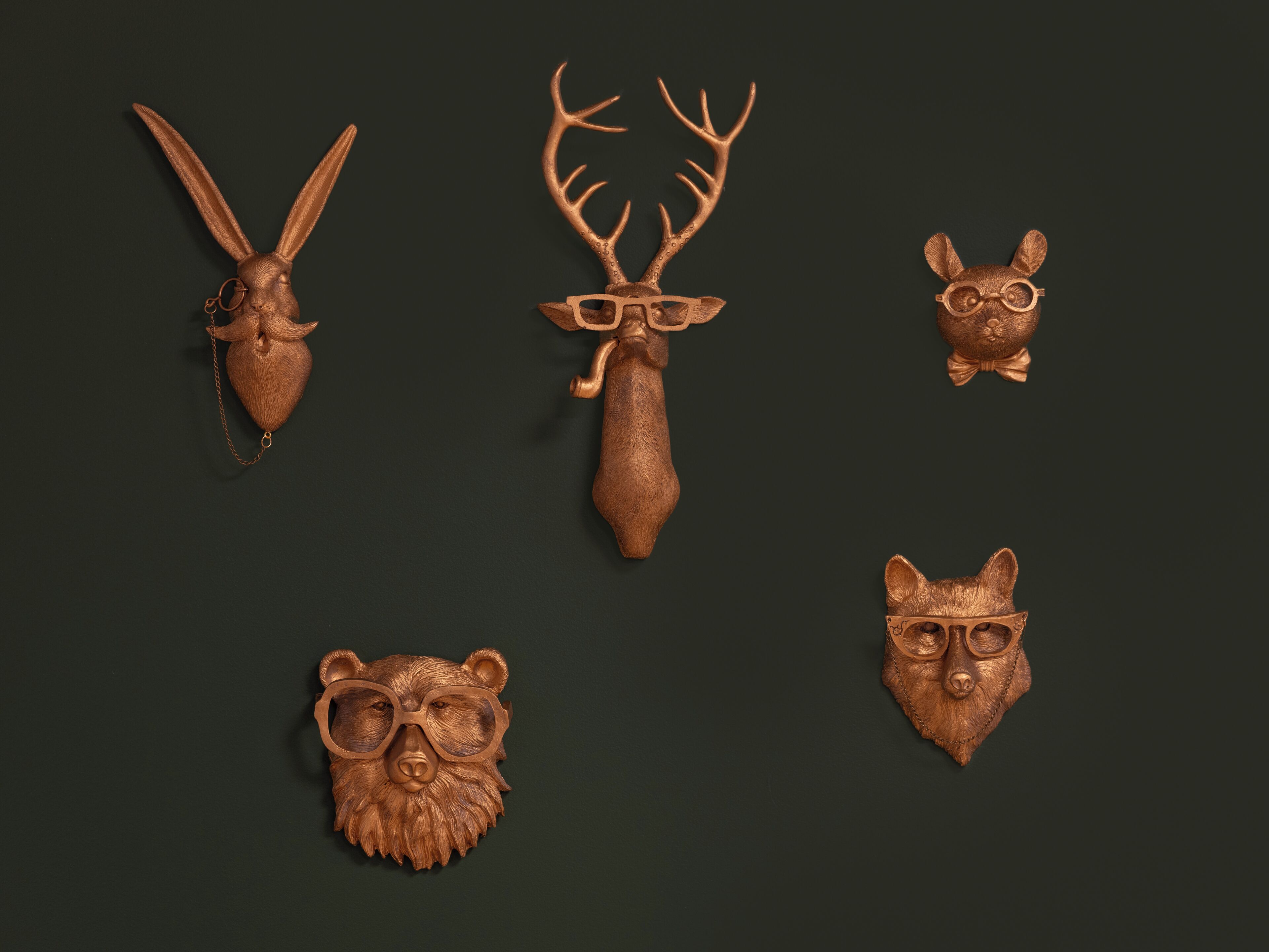 Five wooden animal head sculptures.