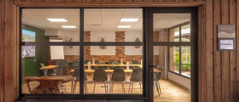 A conference room with a large table, chairs, and a wooden wall.