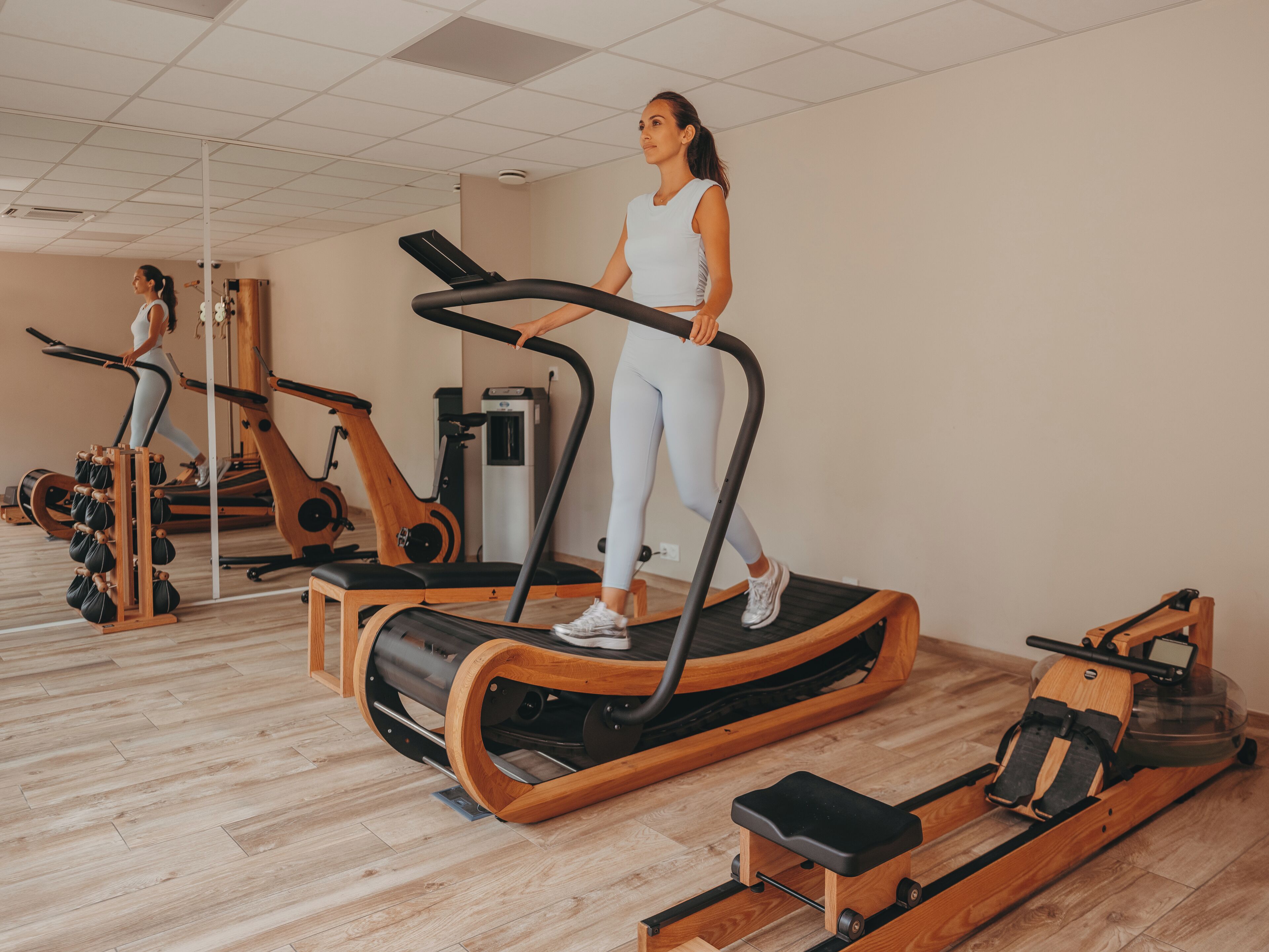 A gym with exercise equipment, including treadmills and a rowing machine.