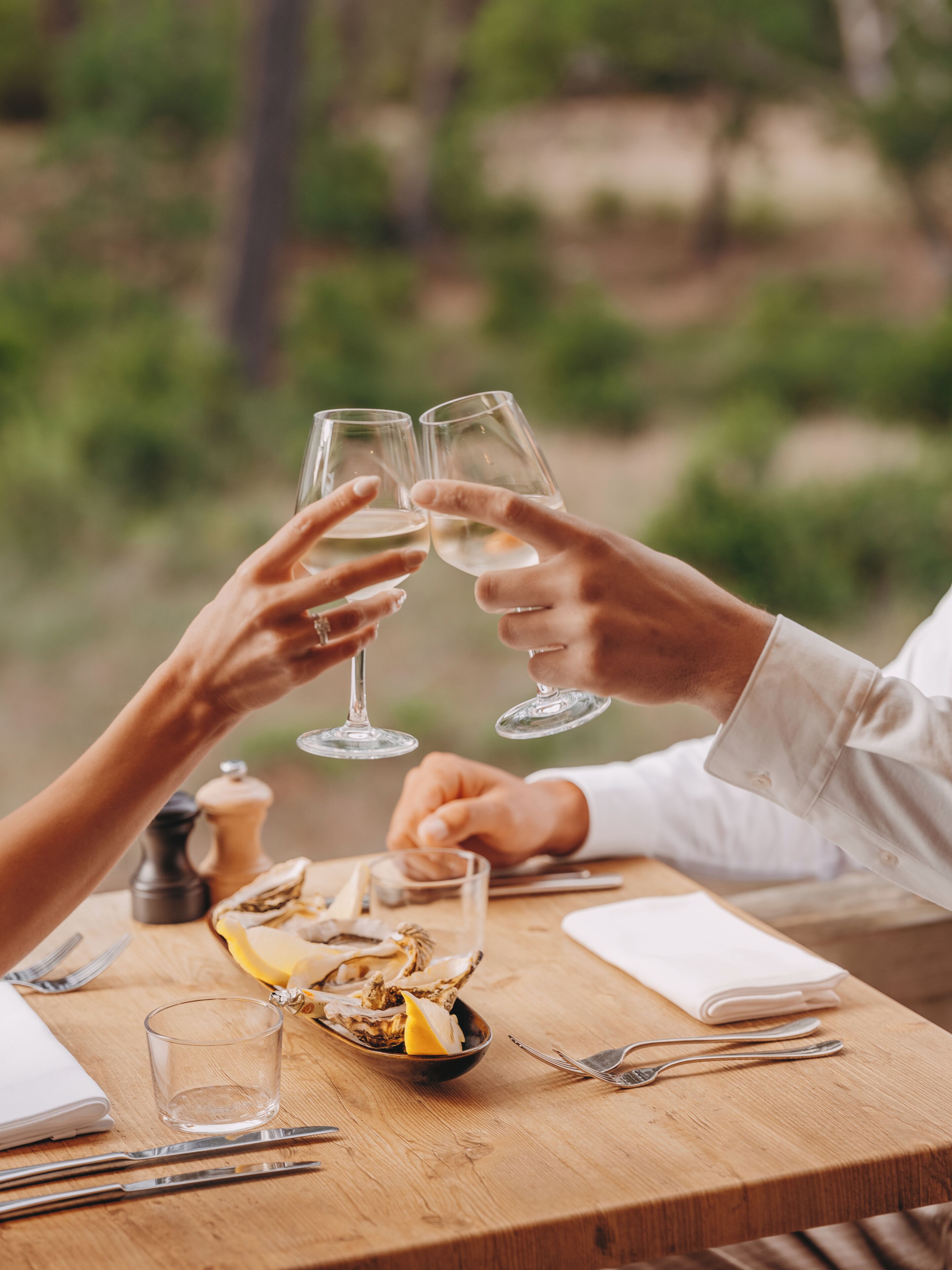 A wooden table with a glass of water, a plate with lemon slices, and a folded napkin.