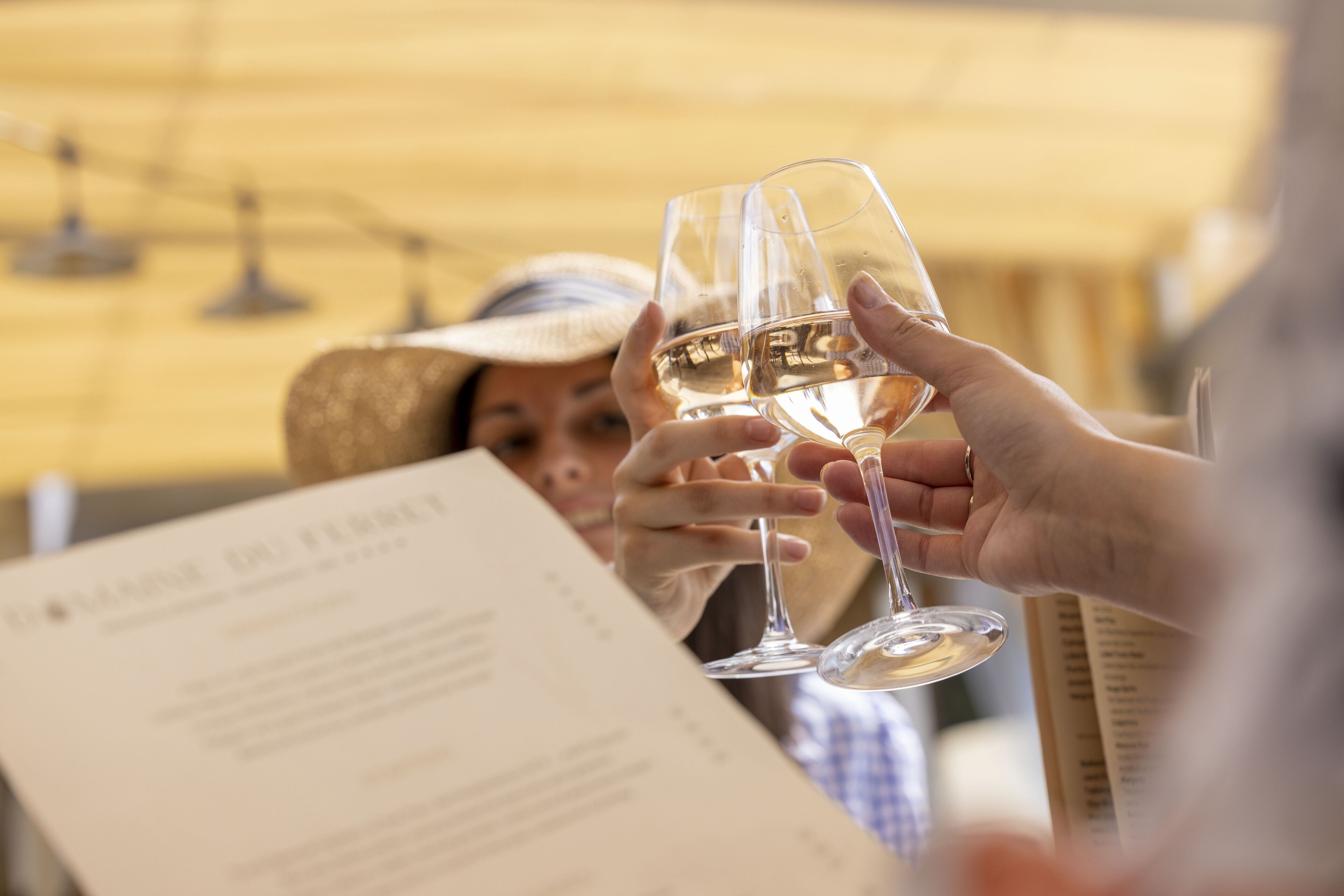 A person holding a wine glass with a menu in front of them.