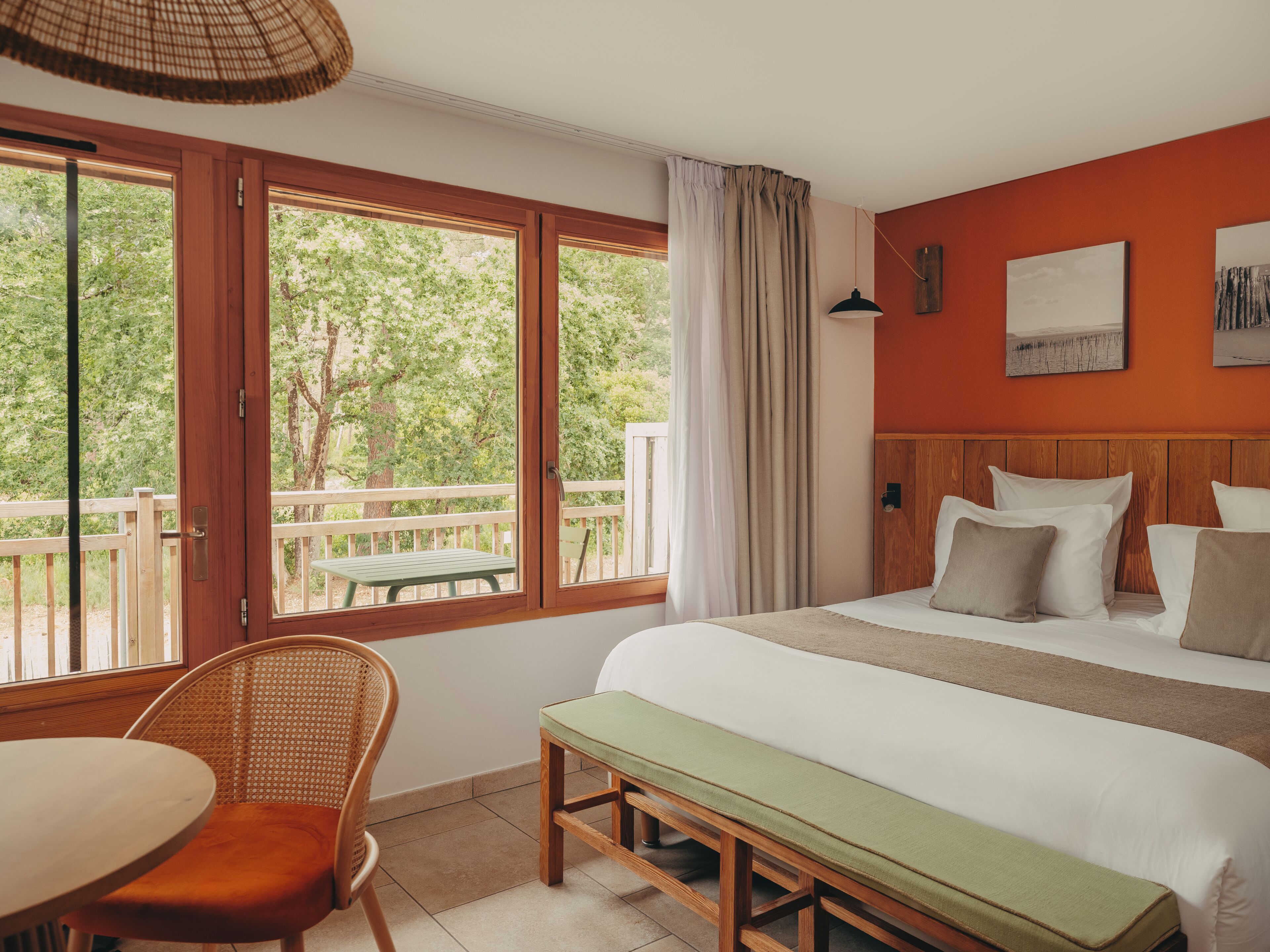 Habitación de hotel con cama, una mesa de comedor, una silla y vistas al exterior.