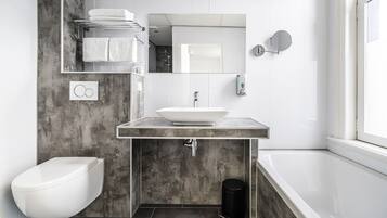 A modern bathroom with a white sink, a toilet, and a bathtub.